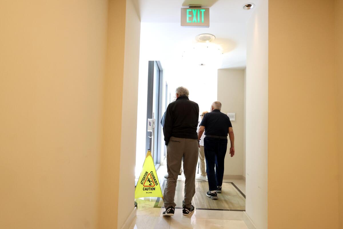 Joe Halper, de 95 años, a la derecha, y Bill Klein, de 94 años, caminan por un pasillo en Avocet Playa Vista el 28 de julio de 2025