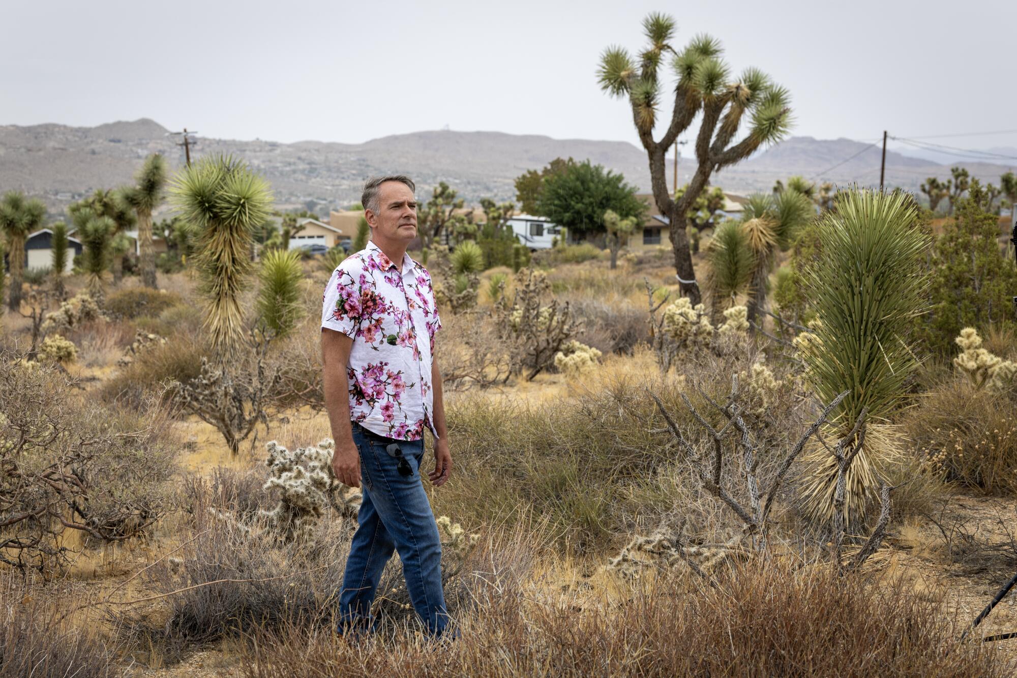 Alec Mackie camina por su propiedad de 1.2 acres, donde quiere construir una casa de jubilación, en Yucca Valley.