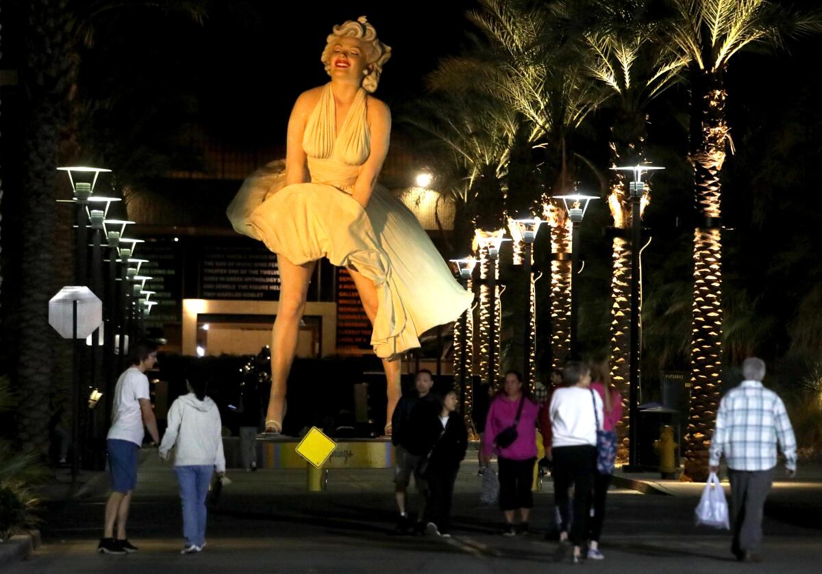 El "Forever Marilyn" La estatua se eleva sobre los visitantes que asisten al semanal Palm Springs Villagefest a lo largo del Museum Way.