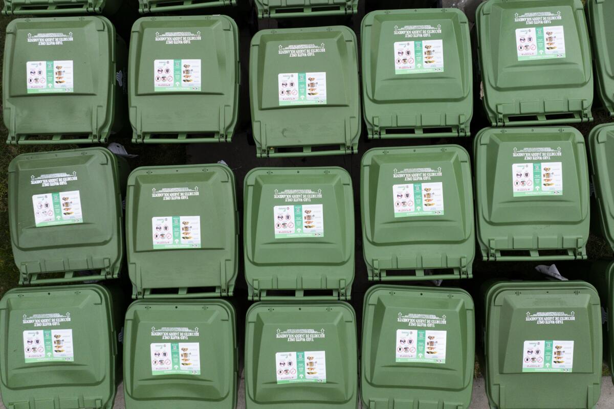 Contenedores de basura verdes afuera de un edificio de departamentos en Koreatown.