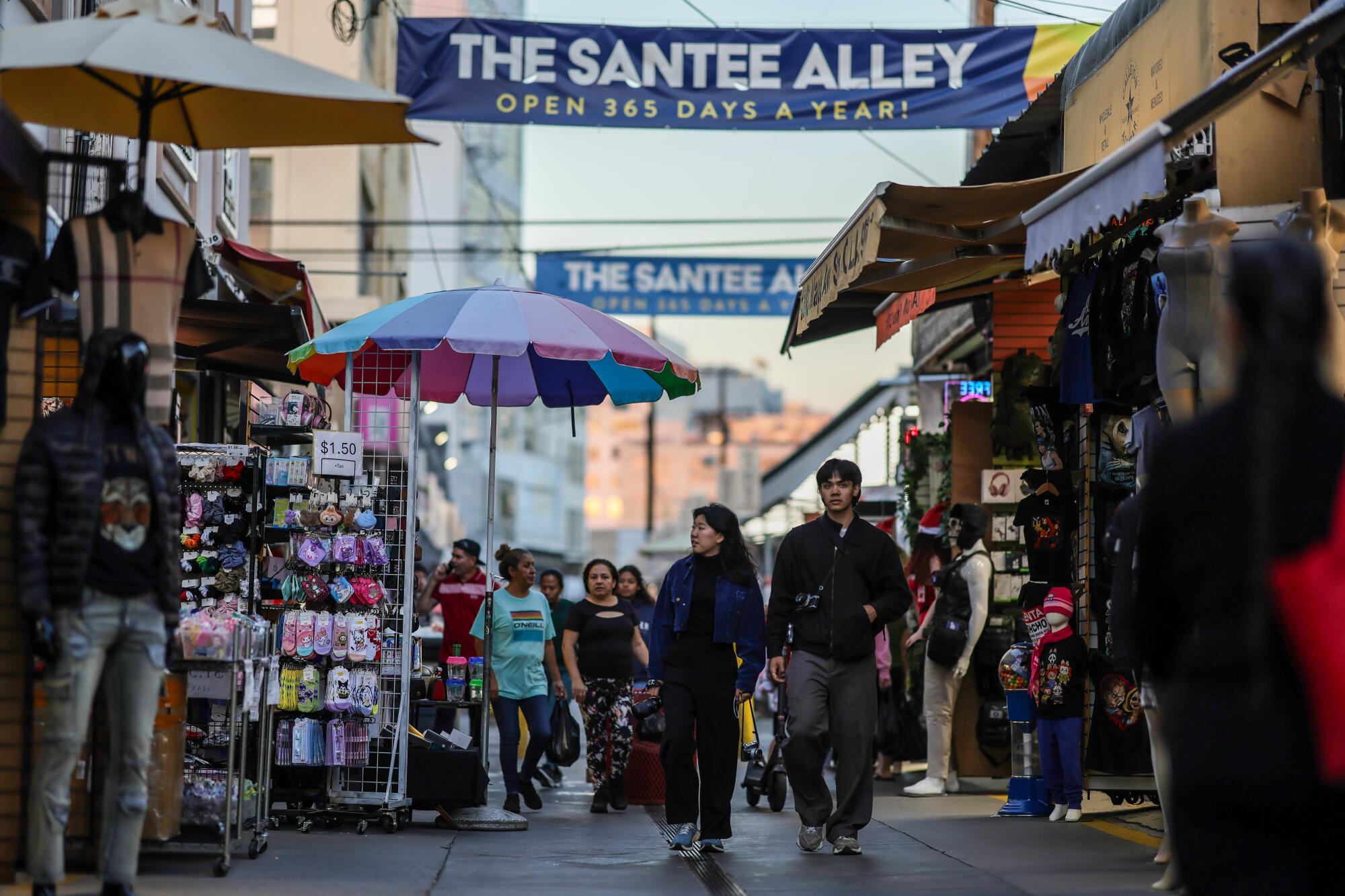 Los compradores pasean por The Santee Alley en el distrito de la moda del centro de la ciudad