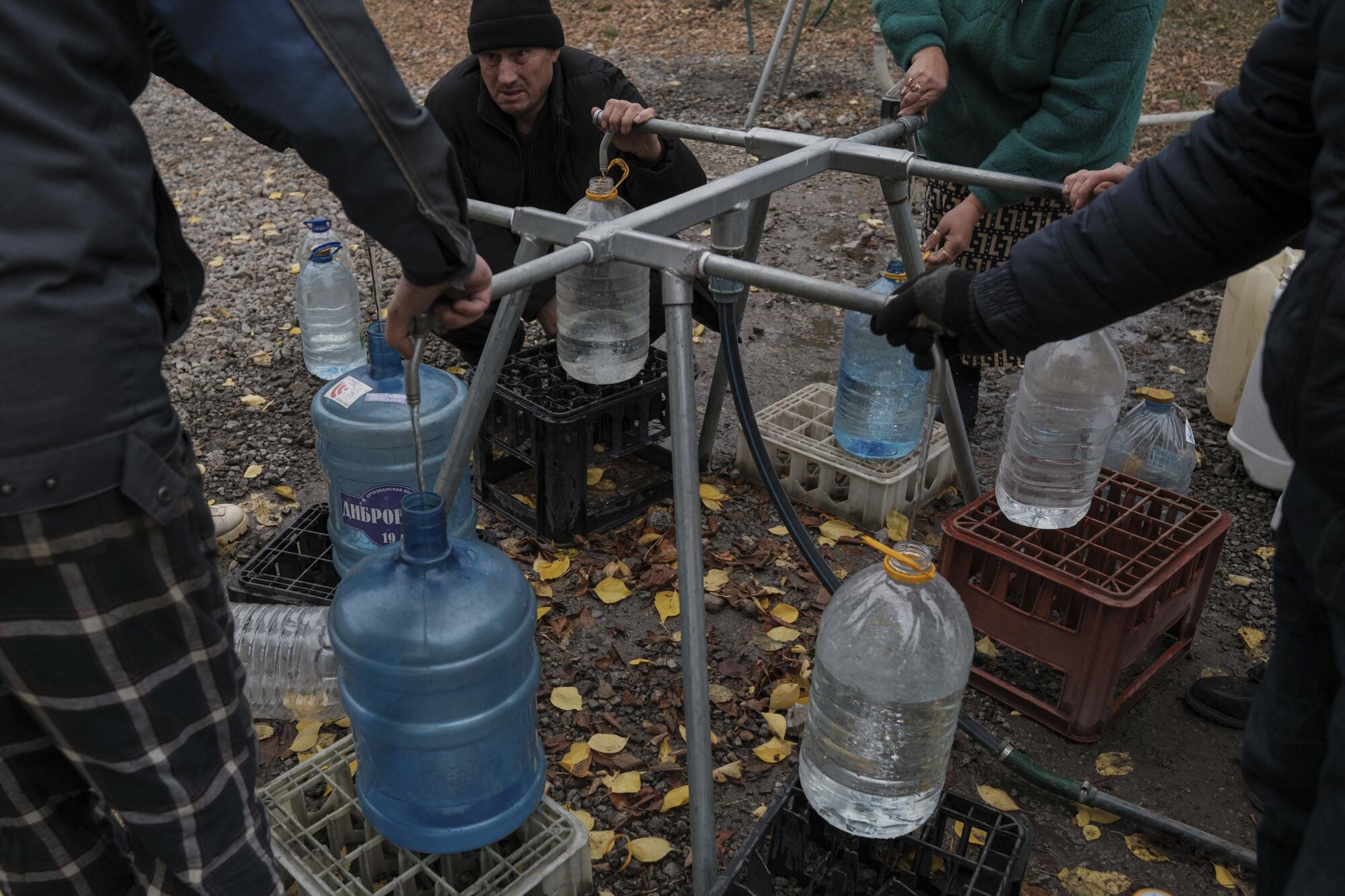 La gente llena agua en botellas.