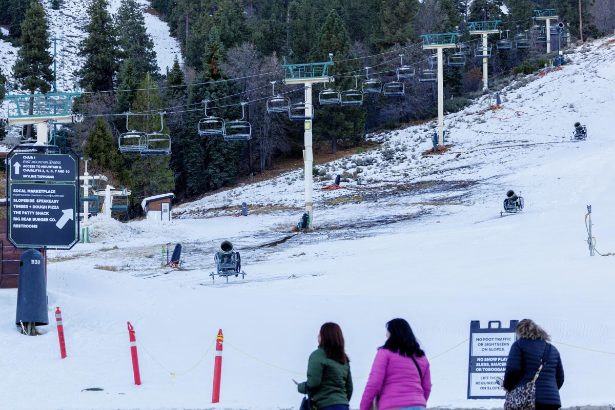 Tres personas se paran frente a un remonte vacío