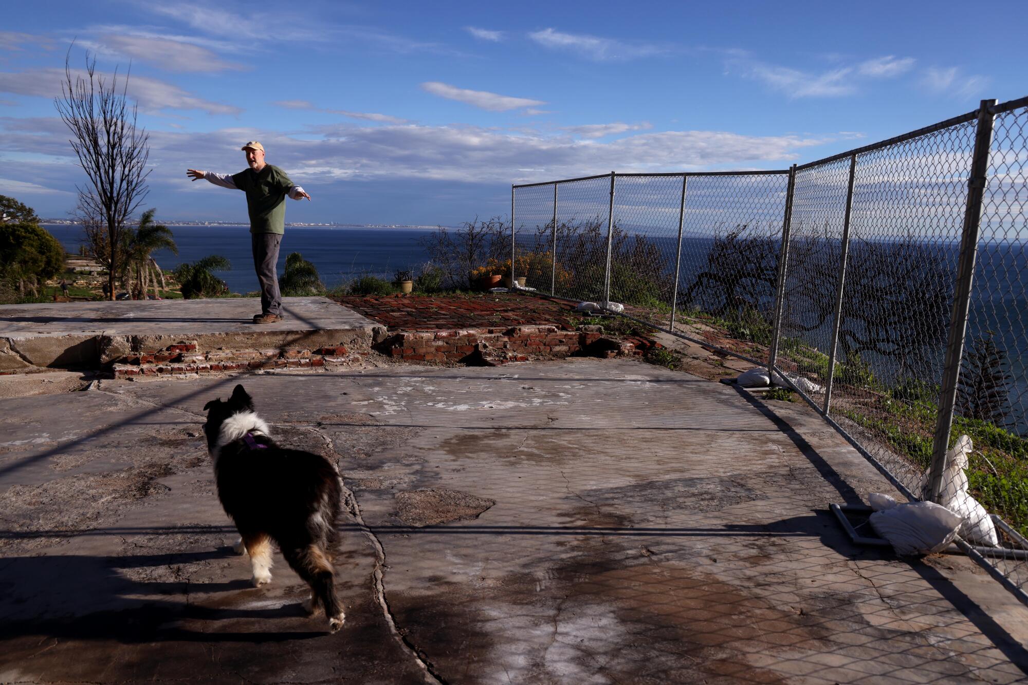 Kraig Hill y su perro, Boudi, se encuentran en los cimientos donde la casa de Hill fue destruida en el incendio de Palisades. 