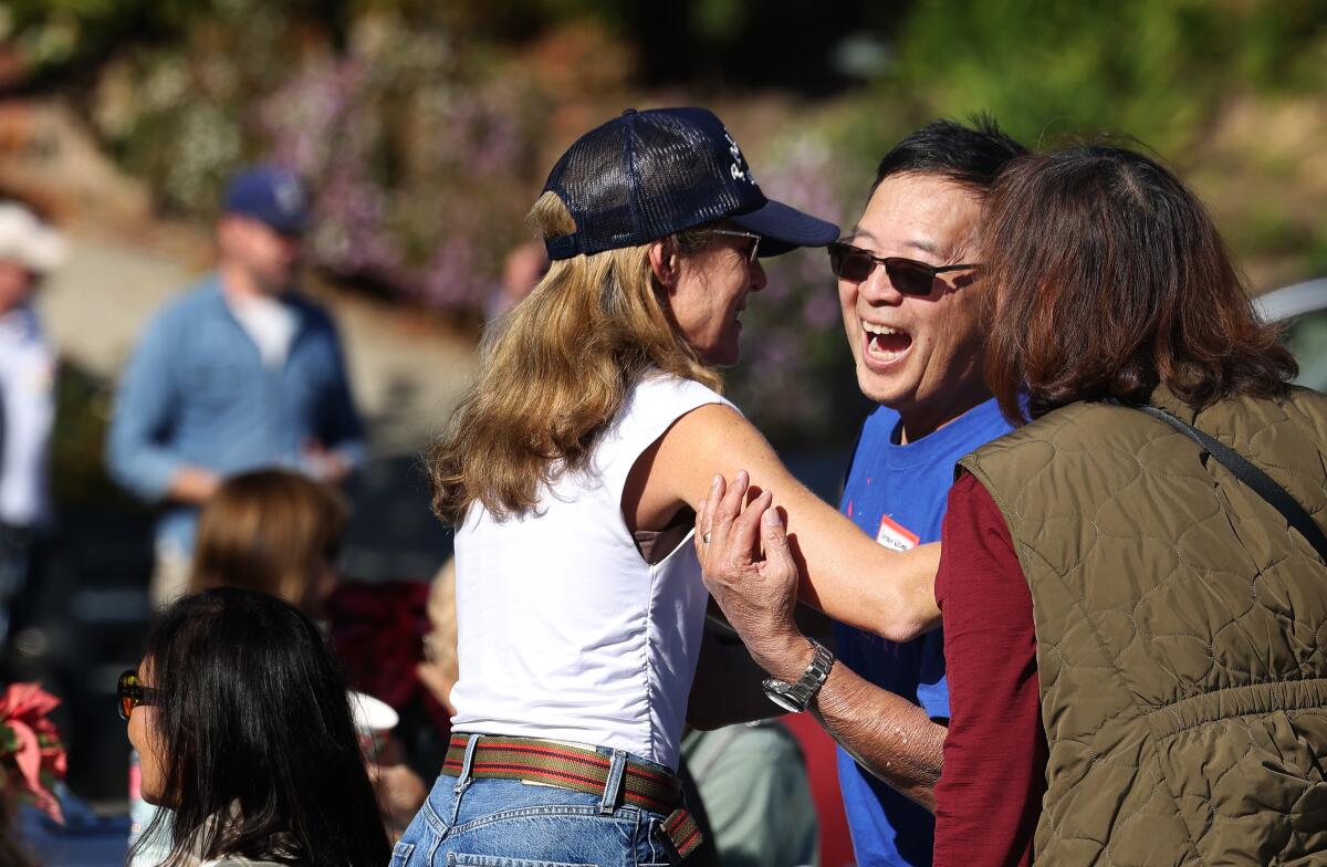 Eleanor Keare, una residente de Pacific Palisades que perdió su casa en el incendio de Palisades, saluda a Gordon y Shirley Wong.